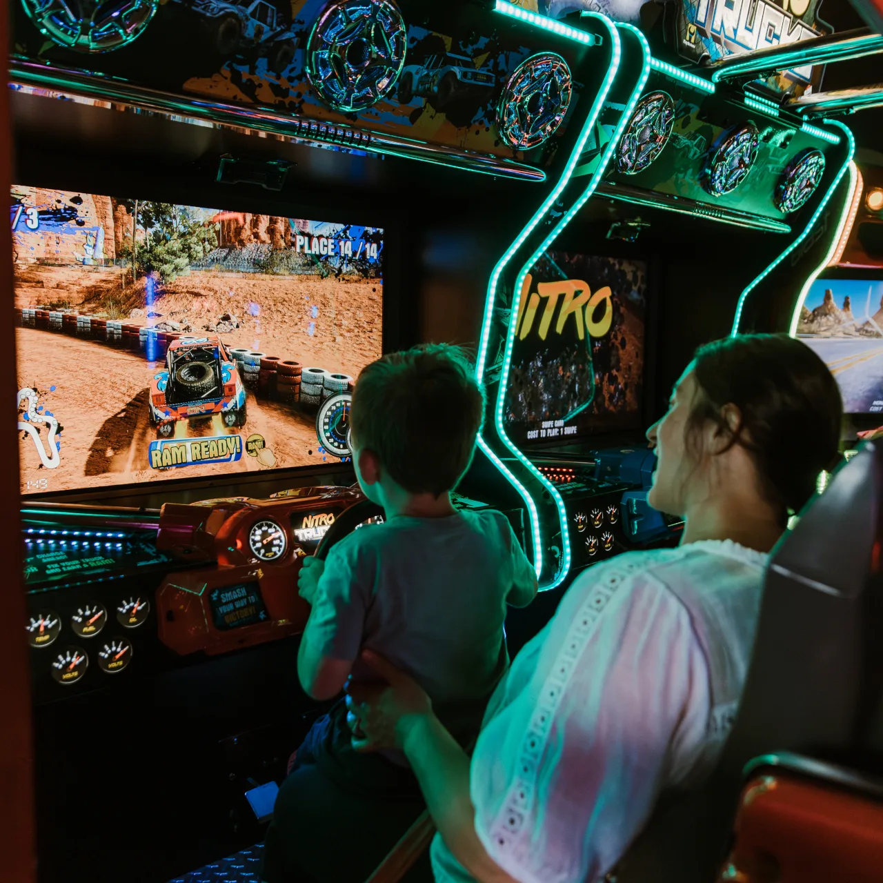 Mom and son playing arcade game in game room at Ocean5